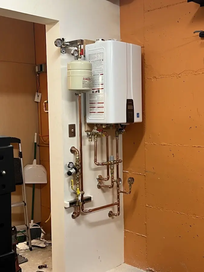 Plumbing technician inspecting water heater connections in Alexander City